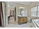 Bathroom with a white tiled floor, vanity with mirror, and soaking tub under a window at 908 Huntington Pl, Peachtree City, GA 30269