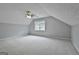 Attic bedroom with neutral carpet, a window, a ceiling fan, and sloped ceilings at 908 Huntington Pl, Peachtree City, GA 30269