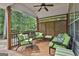 Inviting covered deck with comfortable green seating and wooded views at 908 Huntington Pl, Peachtree City, GA 30269