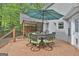 Outdoor deck features dining set with umbrella with wooded views at 908 Huntington Pl, Peachtree City, GA 30269