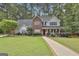 Charming two-story home with a brick facade, a welcoming front porch, and manicured landscaping at 908 Huntington Pl, Peachtree City, GA 30269