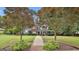 Beautiful two-story home with a red door, lush landscaping, and mature trees at 908 Huntington Pl, Peachtree City, GA 30269