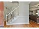 Bright foyer featuring hardwood floors, staircase with white railings, and views into living spaces at 908 Huntington Pl, Peachtree City, GA 30269