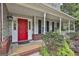 Inviting front porch with a bright red door, black shutters, and well-maintained landscaping at 908 Huntington Pl, Peachtree City, GA 30269