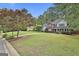 Spacious front yard featuring a well-manicured lawn and mature trees surrounding the property at 908 Huntington Pl, Peachtree City, GA 30269