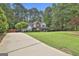 Expansive front yard with mature trees and a long driveway leading to the charming two-story home at 908 Huntington Pl, Peachtree City, GA 30269