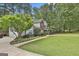 Spacious front yard with mature trees and a long driveway leading to the charming two-story home at 908 Huntington Pl, Peachtree City, GA 30269