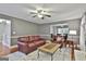 Open living room featuring hardwood floors, ample seating, and view into the dining area at 908 Huntington Pl, Peachtree City, GA 30269