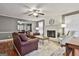 Cozy living room showcasing a brick fireplace, ceiling fan, and hardwood floors at 908 Huntington Pl, Peachtree City, GA 30269