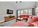 Open living space with hardwood floors, plenty of natural light, and a comfortable red sofa at 908 Huntington Pl, Peachtree City, GA 30269