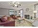 Cozy living room showcasing a fireplace, ceiling fan, hardwood floors, and lots of seating at 908 Huntington Pl, Peachtree City, GA 30269