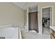 Bright bathroom with a tiled floor, soaking tub and walk in closet at 908 Huntington Pl, Peachtree City, GA 30269