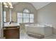 Main bathroom featuring a vanity, a large window, and a separate tub at 908 Huntington Pl, Peachtree City, GA 30269