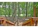 View of the lush backyard from the wooden deck stairs, surrounded by mature trees at 302 Welton Way, Peachtree City, GA 30269