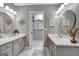 Bathroom with dual vanities, white marble counters and floors and large round mirrors at 302 Welton Way, Peachtree City, GA 30269