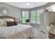 Charming bedroom with plush bedding, decorative mirror, and a sitting area by the window at 302 Welton Way, Peachtree City, GA 30269