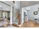 Elegant foyer with hardwood floors, staircase, and view into the living room and dining area at 302 Welton Way, Peachtree City, GA 30269