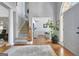 Bright foyer features hardwood floors, staircase with carpeted steps and a view into the dining area at 302 Welton Way, Peachtree City, GA 30269