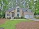 Charming beige two-story home featuring an attached two-car garage and a well-manicured front lawn at 302 Welton Way, Peachtree City, GA 30269