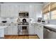 Updated kitchen features stainless appliances, white cabinetry and subway tile backsplash at 302 Welton Way, Peachtree City, GA 30269