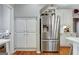 Bright kitchen with stainless steel refrigerator, white cabinets, and wood floors at 302 Welton Way, Peachtree City, GA 30269