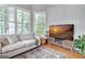 Bright and airy sitting room with hardwood floors and a comfortable white sofa at 302 Welton Way, Peachtree City, GA 30269
