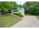 Home with a long driveway and two-car garage surrounded by trees at 142 Pebblebrook Way, Temple, GA 30179