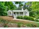 Charming home featuring a covered front porch, bay windows and lush landscaping at 142 Pebblebrook Way, Temple, GA 30179
