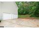 Spacious garage with three doors sits on a concrete driveway, surrounded by green trees at 142 Pebblebrook Way, Temple, GA 30179