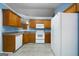 Kitchen featuring oak cabinets and white appliances at 142 Pebblebrook Way, Temple, GA 30179