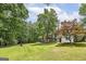 Large backyard with mature trees, a wooden deck, and plenty of green space at 40 Salem Ct, Mcdonough, GA 30252