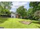 Spacious backyard with lush green grass, mature trees, and wooden play area at 40 Salem Ct, Mcdonough, GA 30252