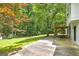 A spacious, grassy backyard with a concrete patio, surrounded by mature trees at 40 Salem Ct, Mcdonough, GA 30252