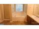 Well-lit bathroom features a soaking tub, tiled floors, and a window for natural light at 6190 Winston Trce, Mcdonough, GA 30252