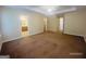 Spacious main bedroom with neutral carpet, tray ceiling, and adjoining main bathroom with a double sink vanity at 6190 Winston Trce, Mcdonough, GA 30252
