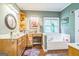 Bathroom featuring wood cabinets, marble countertop, makeup vanity, tub, and window at 871 Rocky Creek Rd, Hampton, GA 30228