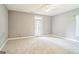 Empty bedroom with carpet, ceiling fan, and white patio door leading to balcony at 871 Rocky Creek Rd, Hampton, GA 30228