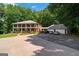 Expansive exterior view of a two-story brick home with a three-car garage and ample parking space at 871 Rocky Creek Rd, Hampton, GA 30228