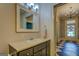 Classic bathroom with gray vanity, neutral walls, and an open doorway to a checkerboard-floored hallway at 3170 Butler Se Ave, Covington, GA 30014