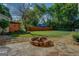 Stone fire pit in the back yard with an outdoor entertaining space and mature trees surrounding it at 3170 Butler Se Ave, Covington, GA 30014