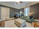 Inviting living space featuring a comfortable couch, patterned ottoman, and a dedicated desk area at 3170 Butler Se Ave, Covington, GA 30014