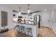 Stylish kitchen with white cabinets, stainless steel appliances, granite countertops, island with seating, and wood flooring at 705 Berry Ct, Villa Rica, GA 30180