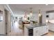Open-concept kitchen features an island with a wine fridge, granite countertops, pendant lighting, and seamless flow to the living area at 705 Berry Ct, Villa Rica, GA 30180