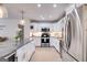 Well-lit kitchen boasting stainless steel appliances, white cabinetry, granite counters, and a spacious island, ideal for cooking at 705 Berry Ct, Villa Rica, GA 30180