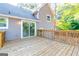 Spacious wooden back deck with stairs leading down to a backyard in a gray home at 8500 Bowen Ct, Jonesboro, GA 30238