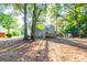 Backyard of home featuring a wooden deck, surrounded by mature trees and a chain link fence at 8500 Bowen Ct, Jonesboro, GA 30238