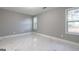 Bedroom featuring large windows providing natural light and sleek white tile floor at 8500 Bowen Ct, Jonesboro, GA 30238