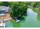 Aerial shot of a waterfront home with a private dock, set on a lush green lake surrounded by trees at 1130 S Rudder Rd, Cumming, GA 30041
