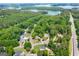 Aerial view showcasing the neighborhood with mature trees, well-maintained homes, and a serene lake in the background at 1130 S Rudder Rd, Cumming, GA 30041