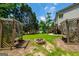 Backyard with stone fire pit, swings, mature trees, and a lush lawn offers a serene outdoor experience at 1130 S Rudder Rd, Cumming, GA 30041
